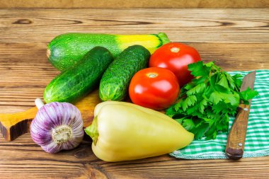 Arka bahçe sebzeleri, domates, salatalık, sarımsak, biber, maydanoz, ahşap arka plan.