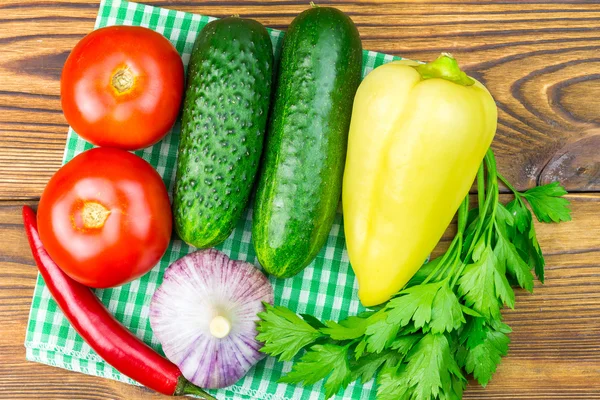 Arka bahçe sebzeleri, domates, salatalık, sarımsak, biber, peçete üzerine maydanoz, ahşap arka plan.