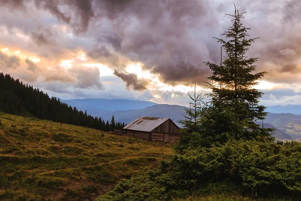 Pintoresco paisaje de montañas de los Cárpatos. Casa bajo la colina, paisaje de puesta de sol . —  Fotos de Stock