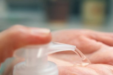 Dezenfeksiyon için dezenfektan jeli kullanan eller ve koronavirüsü önlemek için, Covid-19 enfeksiyonu, antibakteriyel antiseptik ile avuç içi temizleme, yakın görüş..