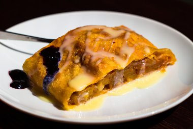 Dilim elma strudel çatal, koyu ahşap masa ile plaka üzerinde