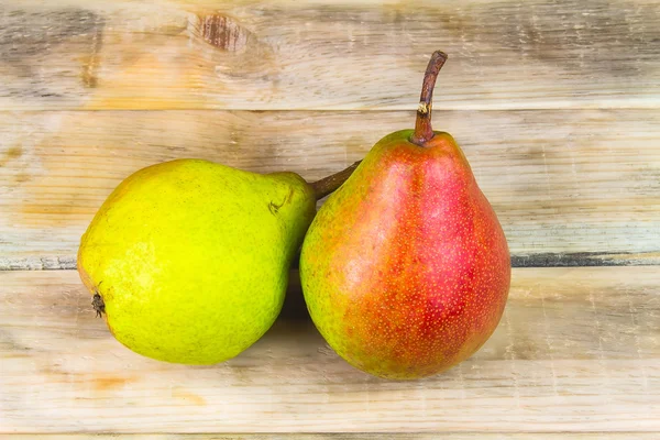 Two ripe green and red pears on rustic wooden background — Stock Photo, Image