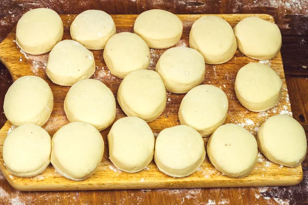 Petites boules de pâte fraîche maison sur planche de bois farinée — Photo