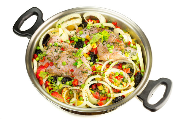Healthy food, uncooked dietary rabbit meat with various  vegetables in pan, isolated on white background, top view