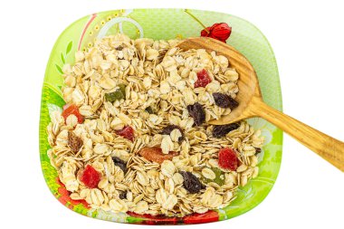 Beyaz arka plan üzerinde üstten görünüm izole tahta kaşıkla tabakta kuru meyve ile yulaf gevreği