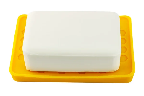 Sabão branco sobre suporte amarelo isolado sobre fundo branco — Fotografia de Stock