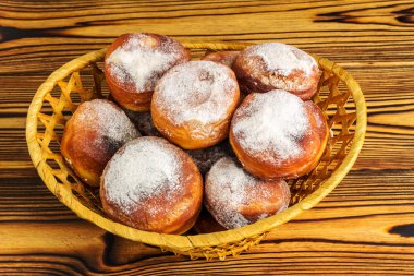 Ev yapımı taze çörek ahşap masa, üstten görünüm üzerinde hasır sepet içinde pudra şekeri serpilir