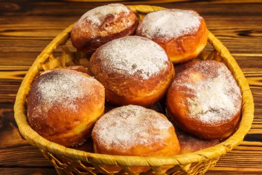 Ev yapımı taze çörek serpilir ahşap tablo, hasır sepet içinde pudra şekeri ile yakın çekim