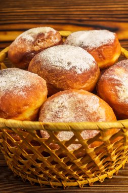Ev yapımı taze çörek serpilir ahşap tablo, hasır sepet içinde pudra şekeri ile yakın çekim