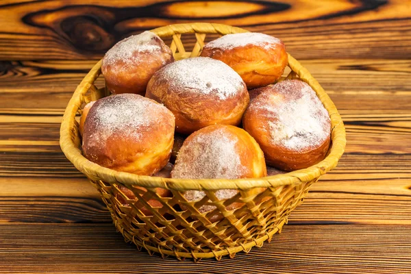 Ev yapımı taze çörek hasır sepet ahşap masa üzerine pudra şekeri serpilir — Stok fotoğraf