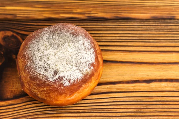 Homemade fresh donut sprinkled with powdered sugar on wooden table, top view. with space for text — Stock Photo, Image