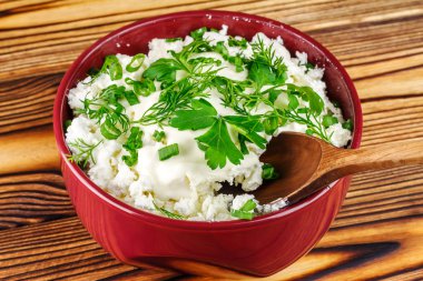 Ekşi krema, dereotu, maydanoz, soğan ve ahşap masa, metin için yer üzerinde seramik kase kaşık ile taze peynir