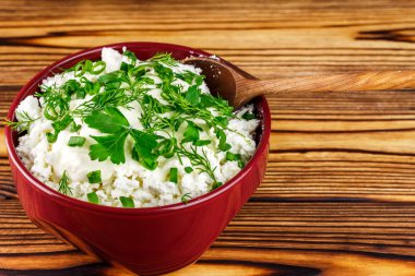 Ekşi krema, dereotu, maydanoz, soğan ve ahşap masa, metin için yer üzerinde seramik kase kaşık ile taze peynir