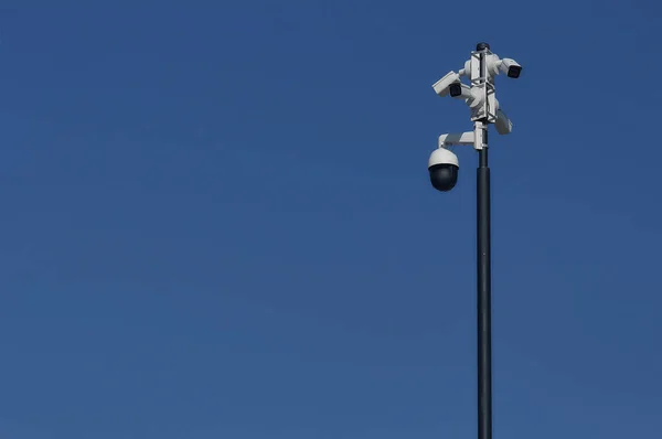 Video surveillance system against the blue sky. Five video cameras are mounted on one pole.