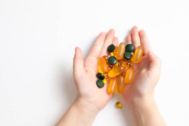 Çocuk avuçlarında bir avuç dolusu hap ve vitamin var. Sağlık hizmeti. Covid 'in önlenmesi. Dokunulmazlık. Sağlıklı bir yaşam tarzı. Besin takviyeleri. Vejetaryen. beyaz arkaplan genel planı