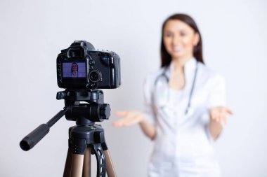Tıbbi bir video bloğu için çekim. Kadın bir doktor aboneleri ve hastaları için bir eğitim videosu kaydediyor. Doktor blog yazarı. Doktor hatta. Teletıp. Yüksek kalite fotoğraf