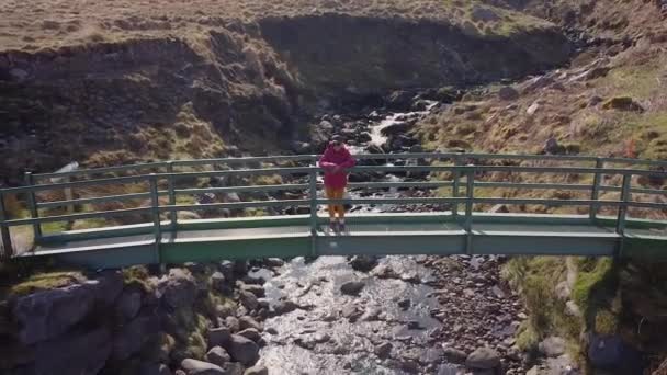 Dron Powietrzny Nakręcił Kobietę Różowej Kurtce Zielonym Moście Górach Kerry — Wideo stockowe
