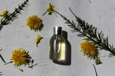 Beyaz arka planda doğal çiçek ve yapraklarla bembeyaz bir güzellik ürünü şişesinin düz kompozisyonu