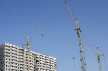 İnşaat vinçleri ve gökyüzü arka plan üzerinde bina.