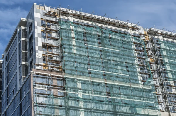 koruyucu bir kafes ile yapım aşamasında bir binanın cephe