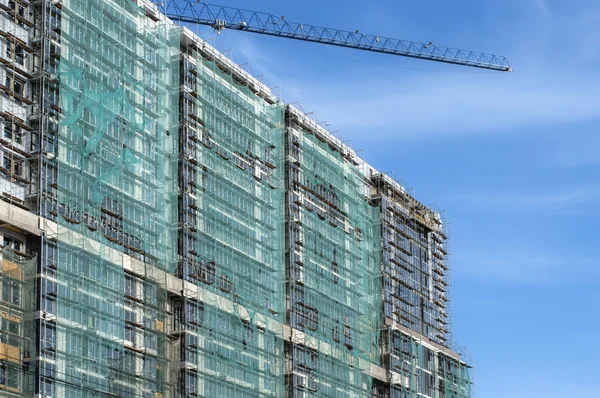 koruyucu bir kafes ile yapım aşamasında bir binanın cephe