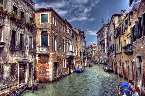 Boats & Gondola down a street canal off the Grand Canal in Venice, Italy