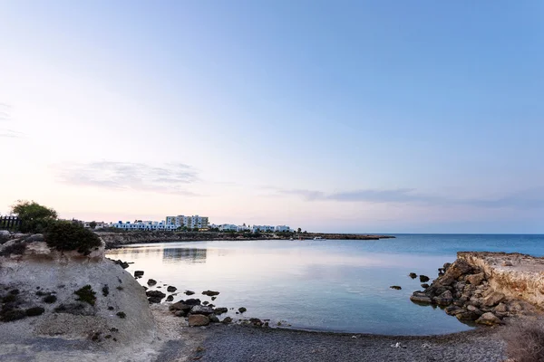 Photo of sea in protaras, cyprus island, with rocks and hotels at sunset. — Stock Photo, Image