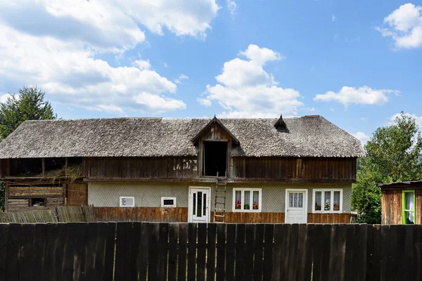 Foto de casa de madera tradicional y bosque verde en las montañas de Brasov por la mañana, Rumania . —  Fotos de Stock