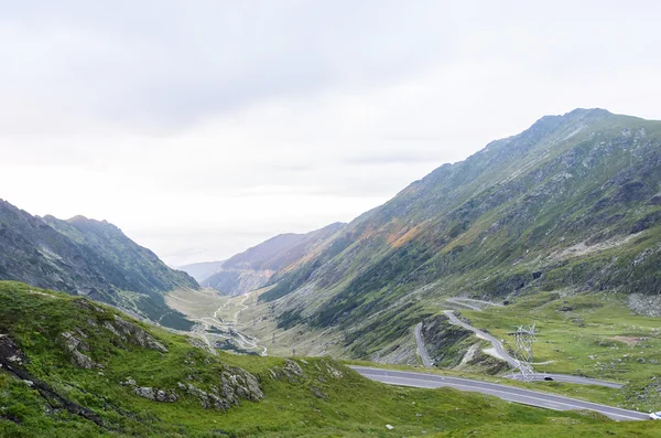 Foto de la famosa carretera sinuosa en las montañas Fagaras al atardecer, Rumania . —  Fotos de Stock