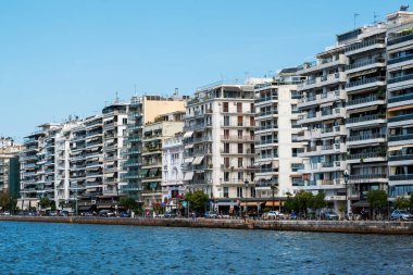 THESSALONIKI, GREECE - 21 Eylül 2020: Geçen arabaları, yüksek binaları ve deniz kıyıları olan yürüyen insanlar