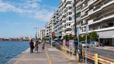 THESSALONIKI, GREECE - 21 Eylül 2020: Geçen arabaları, yüksek binaları ve deniz kıyıları olan yürüyen insanlar