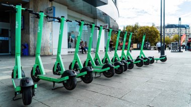 BUCHAREST, ROMANIA - 28 Eylül 2020: Arka arkaya park etmiş çoklu yeşil elektrikli cıvata paylaşım scooterları