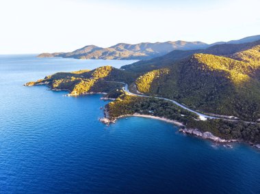 Halkidiki 'de mavi deniz ve dağlarla birlikte gün batımının insansız hava aracı manzarası, Yunanistan