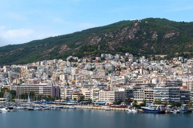 Ege Denizi 'nde liman ve demirli yatları olan birden fazla bina, Yunanistan' ın Kavala kentindeki yeşil tepe