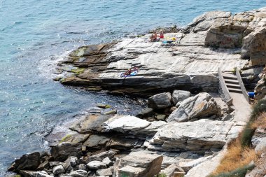 Yunanistan 'ın Kavala kentinde Ege kayalıklarında dinlenen insanların maliyeti
