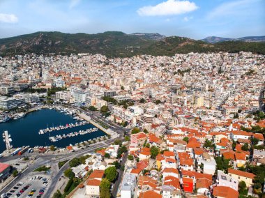 Çok sayıda bina, arka planda yeşil tepeler, liman ve demirli yat ve karayolu ile Ege denizi maliyeti, Yunanistan 'ın Kavala kentindeki insansız hava aracının manzarası