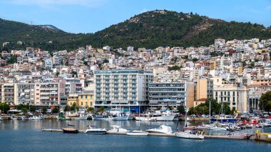 Ege Denizi 'nde liman ve demirli yatları olan birden fazla bina, Yunanistan' ın Kavala kentindeki yeşil tepe