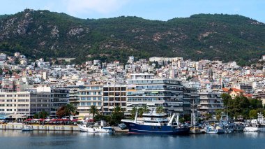 Ege Denizi 'nde liman ve demirli yatları olan birden fazla bina, Yunanistan' ın Kavala kentindeki yeşil tepe