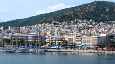 Ege Denizi 'nde liman ve demirli yatları olan birden fazla bina, Yunanistan' ın Kavala kentindeki yeşil tepe