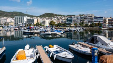 KAVALA, GREECE - 23 SEPTEMBER 2020: Limanda bir sürü demirli tekne, Ege 'deki deniz maliyeti binalar, arka planda yeşil tepe