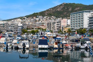 KAVALA, GREECE - 23 SEPTEMBER 2020: Limanda bir sürü demirli tekne, Ege 'deki deniz maliyeti binalar, arka planda yeşil tepe