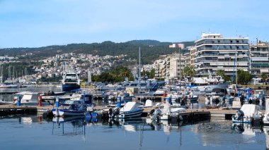 KAVALA, GREECE - 23 SEPTEMBER 2020: Limanda bir sürü demirli tekne, Ege 'deki deniz maliyeti binalar, arka planda yeşil tepe
