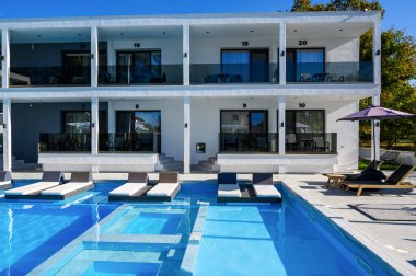 Yunanistan 'ın Asprovalta kentinde havuzu, güneşliği ve birden fazla otel odası girişi bulunan Avaton Lüks Oteli' nin iç mahkemesi