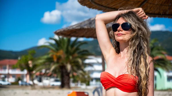 그리스 리비에라 해변에 선글라스를 수영복을 코카서스 여성의 — 스톡 사진