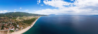 Asprovalta ve Ege 'nin panoraması, birden fazla bina, kasaba boyunca uzun sahil, arka planda yeşil tepeler, Yunanistan