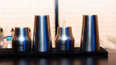 Restoranda kurutulan kokteylleri sallamak için dört metal bardak.