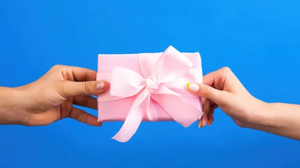 Чоловік Дарує Рожеву Подарункову Коробку Жінці Синьому Фоні Дві Руки — стокове фото