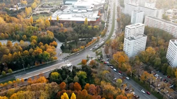 BUCHAREST, ROMÉNIA - OUTUBRO 18, 2020: Uma estrada com carros em movimento, bondes perto do parque Titan, vegetação múltipla. Vista do drone — Vídeo de Stock