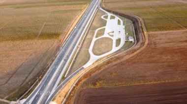 Hareket halindeki arabalarla ve yol kenarına park edilen Güneş Otoyolu, etraftaki tarlalar. İnsansız hava aracının görüntüsü. Romanya