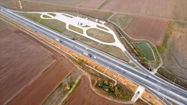 The Motorway of the Sun with moving cars and parking on the side of the road, fields around. View from the drone. Romania